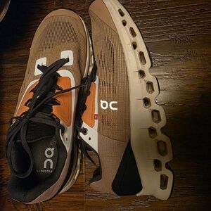 On Running Brown, Orange, and Black Athletic Shoes with CloudTec Cushioning